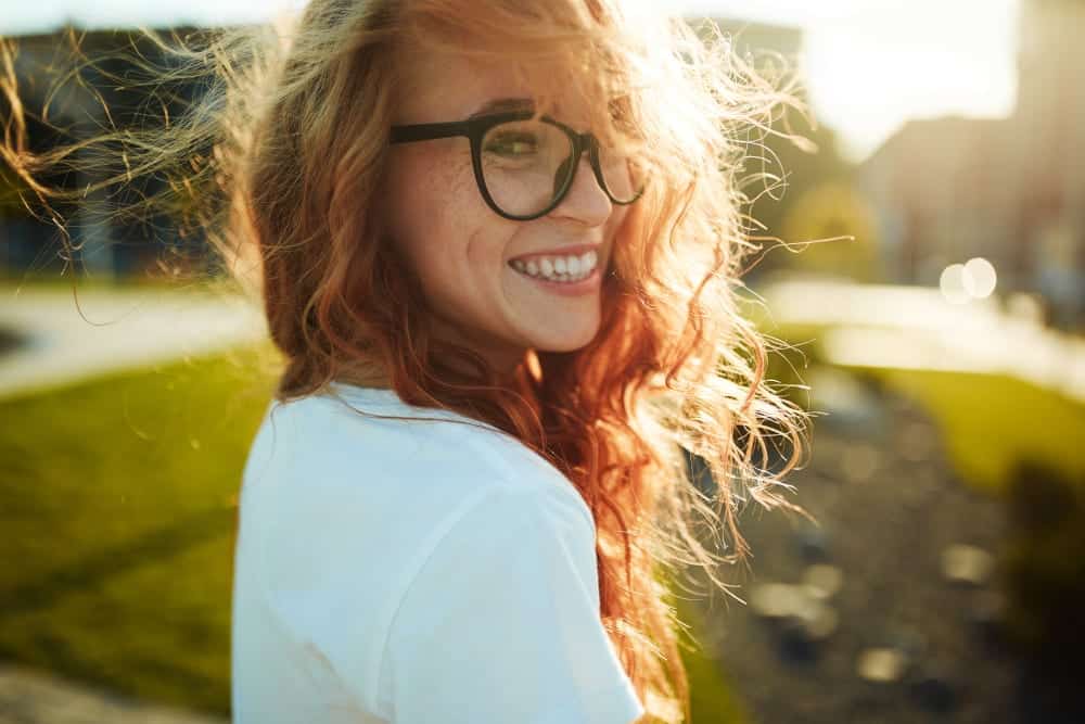 Portrait of a charming red-haired girl with a eyeglasses