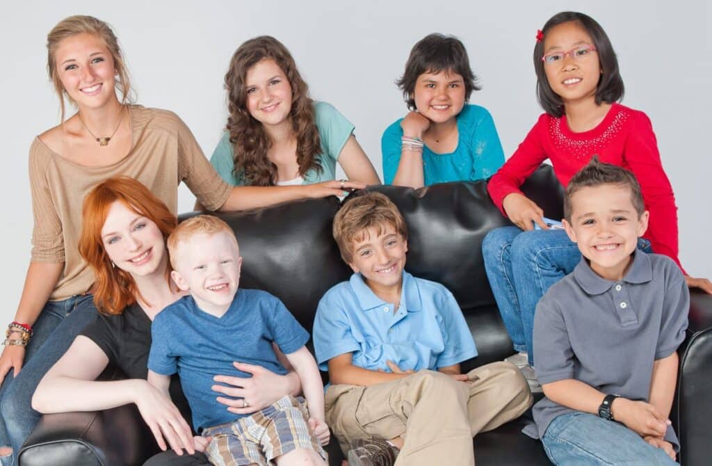 red-hair woman with a lot of kids around a sofa