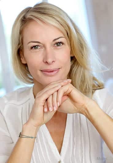 beautiful blonde woman with her face resting on her hands