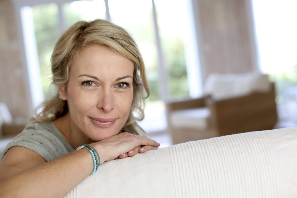 middle aged woman's face resting on her hands 