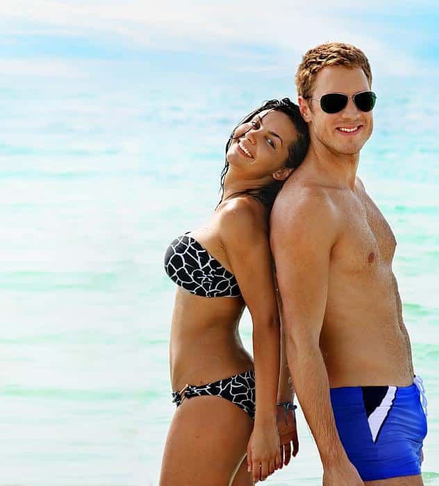 man and young woman back to back on the beach