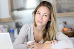 beautiful young woman smiling with her arms crossed over the table