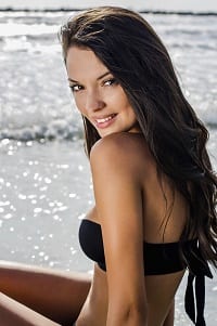 young woman looking over her left shoulder near the sea