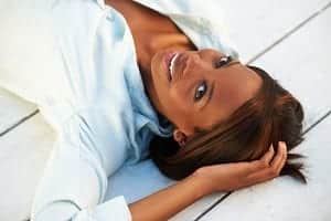 gorgeous smiling woman lying down with one hand on her head