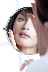 reflection of a young brunette woman in the mirror