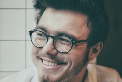 smiling young man's face with glasses