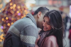Couple embracing in front of christmas lights