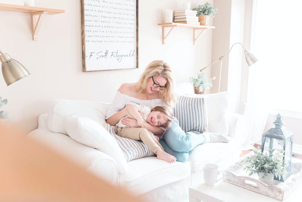 mom and baby on a sofa smiling