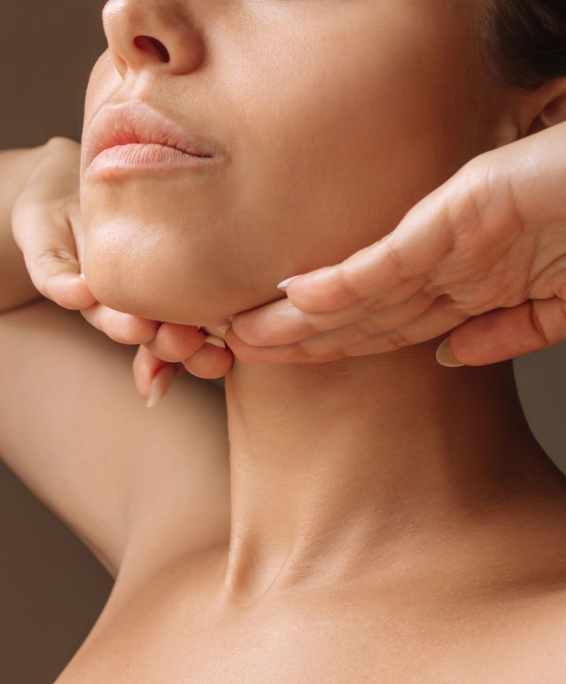 woman with her hand below her chin, defined neckline