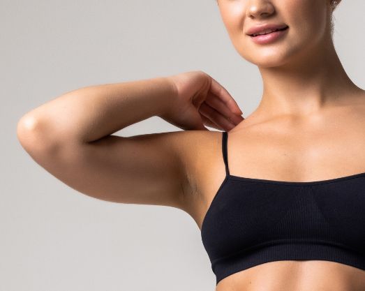 Female top body wearing a black sports bra close up