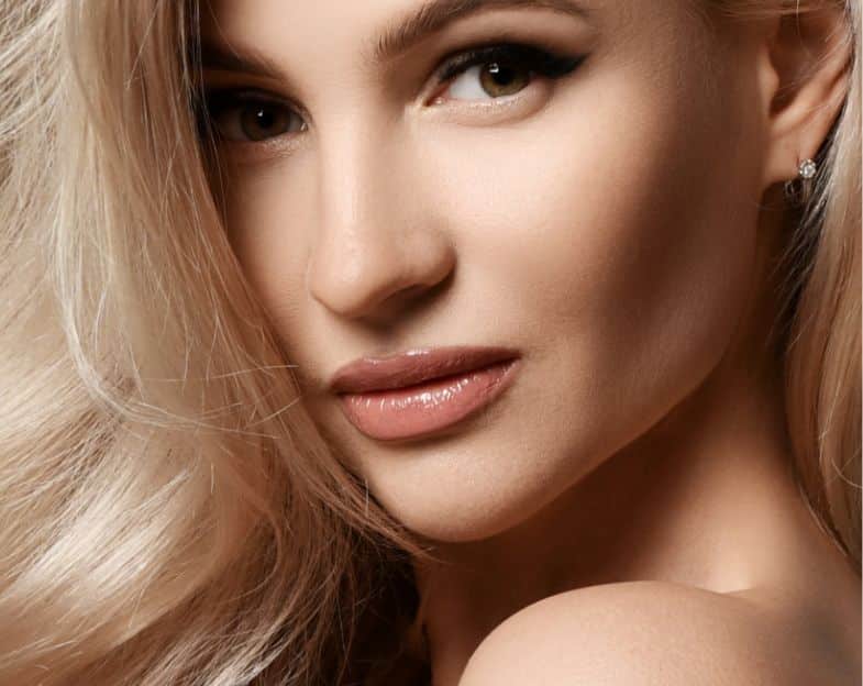 close up of a women's face, looking over her shoulder at the camera