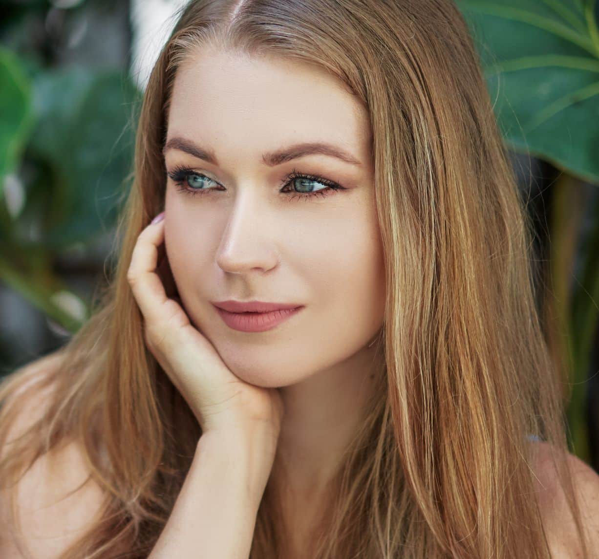 Female looking on the side with one hand on her cheek