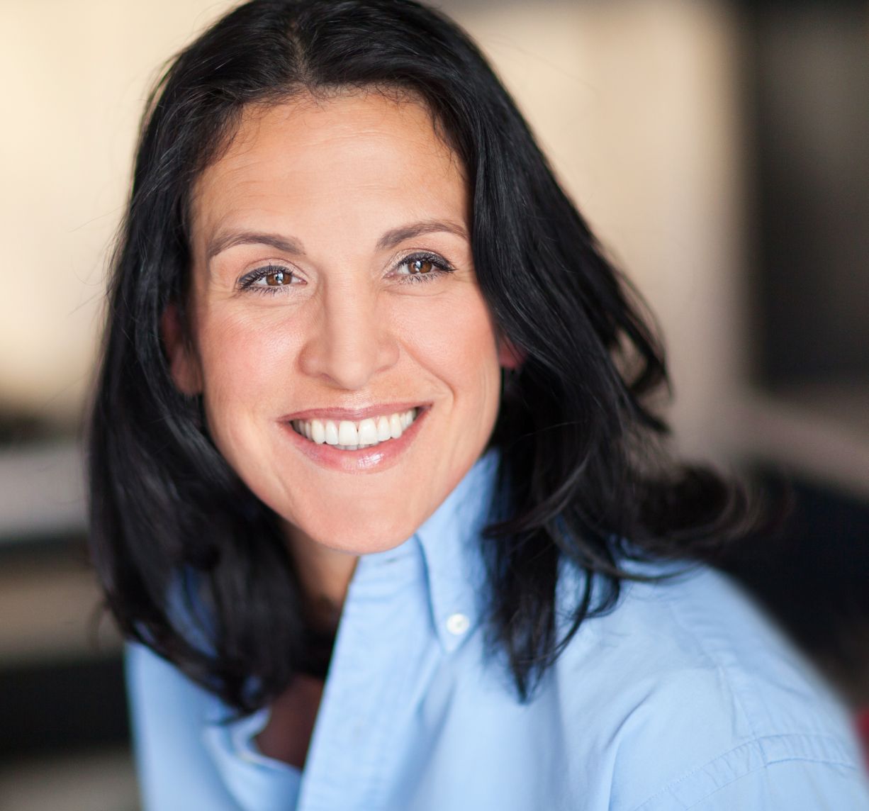 woman wearing a blue collared top smiling
