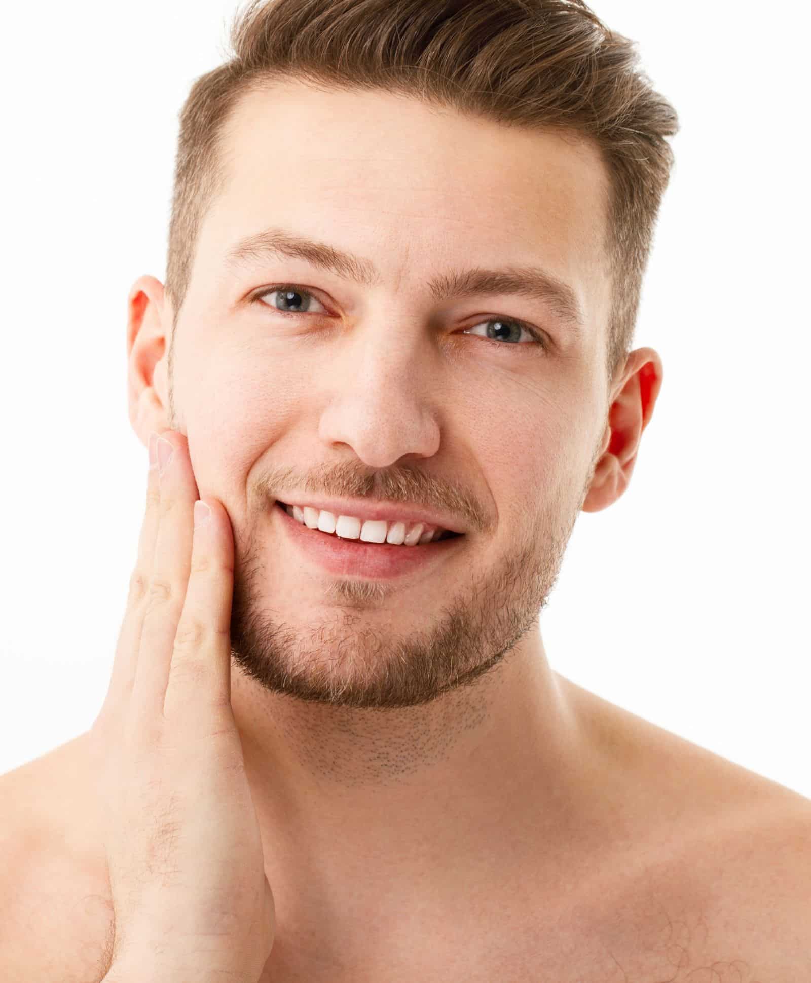 shirtless male touching his face with one hand close up photo