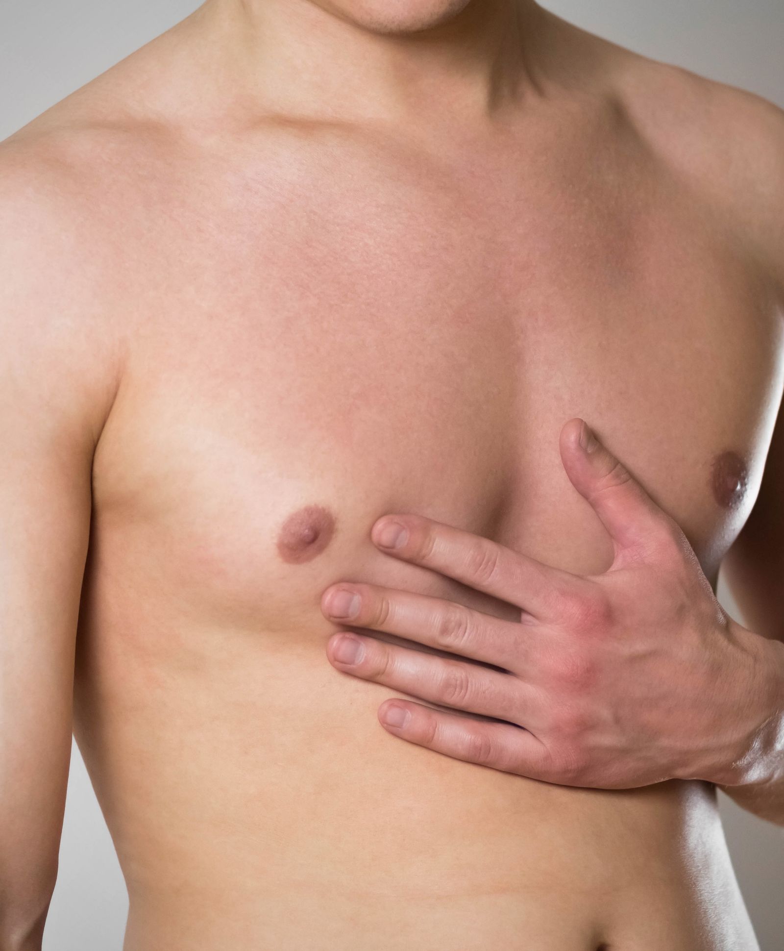 Shirt less male with one hand over this his chest