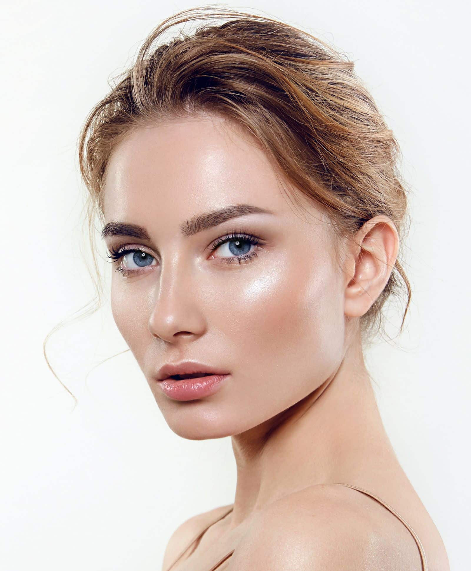Woman lwith glowing skin looking directly into the camera