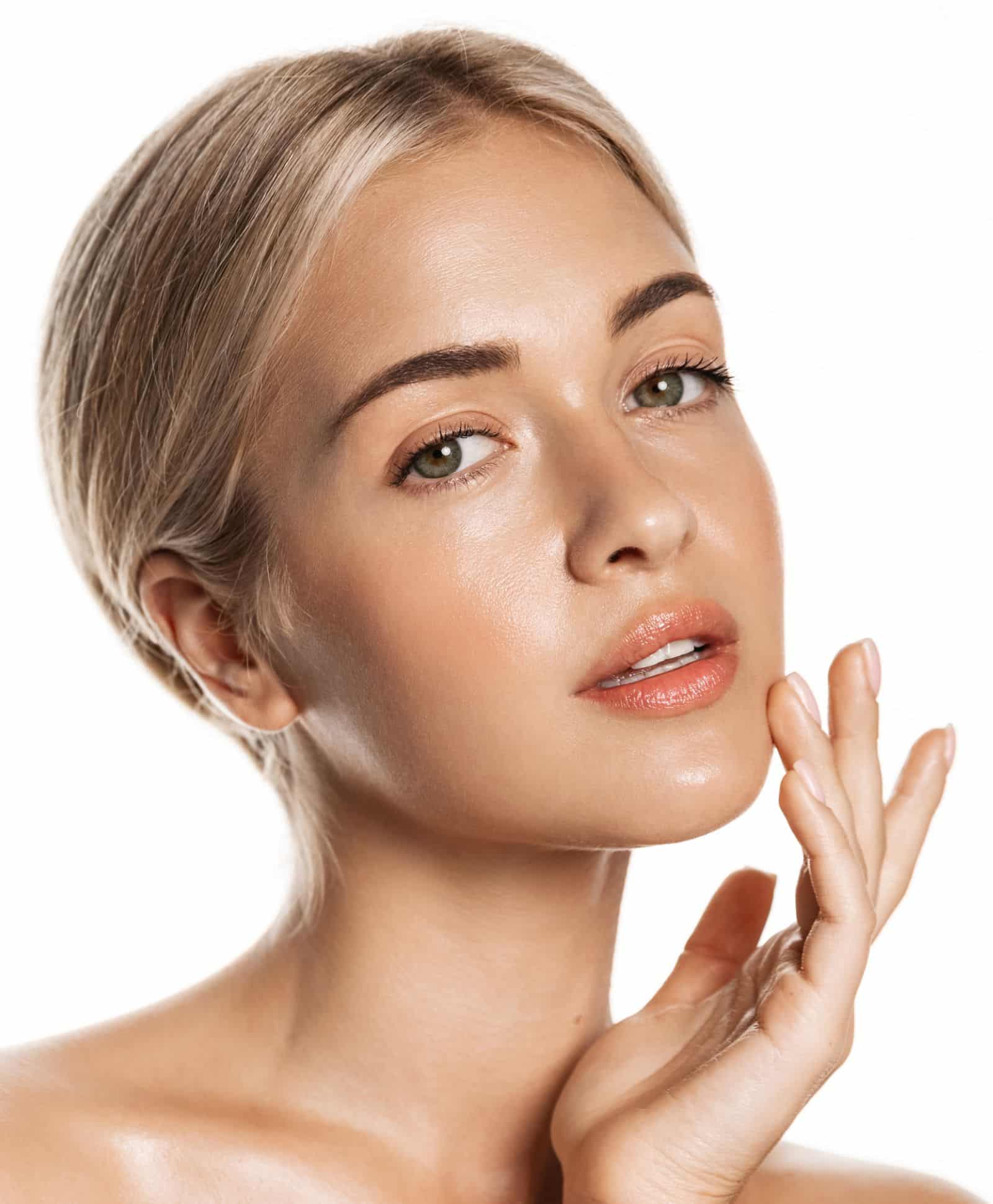 Female face close up photo with one finger touching her face