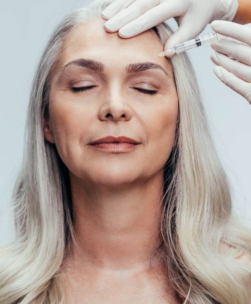Mature woman getting an injectable treatment on her forehead